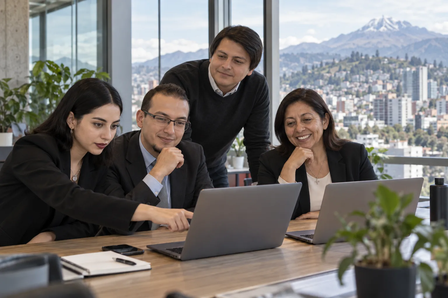 Equipo de Wide Solutions colaborando en oficina con vista a la ciudad de Quito